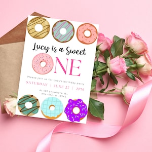 May include: A pink and white birthday invitation with the text "Lucy is a Sweet ONE" and a donut theme. The invitation includes the date and time of the party, as well as the address.