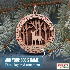 May include: A wooden Christmas bauble featuring a Rat Terrier dog standing in a woodland scene. The bauble is three-layered and has the text "I my Rat Terrier. I my Rat Terrier. I my Rat Terrier. I" around the edge. The dog is labelled "Puppers".