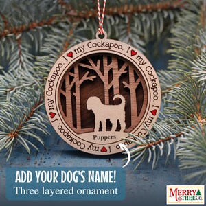 Puede incluir: Un adorno navideño de madera con la silueta de un perro Cockapoo en una escena de bosque. El adorno es de tres capas y tiene el texto "I my Cockapoo. I my Cockapoo. I my Cockapoo" alrededor del borde. El texto "Puppers" está debajo de la silueta del perro.