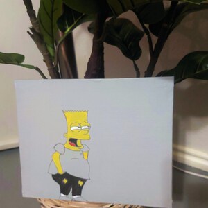 May include: Hand-painted canvas artwork featuring a yellow cartoon character with a mischievous expression. The character is wearing a grey shirt and black pants. The background is a light grey.
