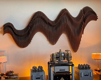May include: A brown wooden wall sculpture in the shape of a wave, with a gold and silver audio system in the foreground. The audio system includes a turntable, amplifier, and speakers.