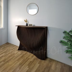Könnte beinhalten: Ein dunkelbrauner Konsolentisch mit einer wellenförmigen, strukturierten Vorderseite. Der Tisch hat ein schlichtes, modernes Design und eignet sich perfekt für einen Flur oder einen Eingangsbereich.