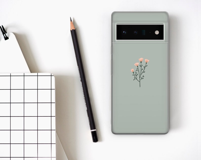 May include: A sage green phone case with a simple floral design featuring pink flowers and green stems.