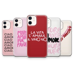 Op de afbeelding: Vijf telefoonhoesjes in roze, rood en wit, elk met Italiaanse zinnen. De hoesjes tonen handgeschreven teksten zoals "Ciao Amor" en "La Vita E' Amara, Il Vino No". Verschillende ontwerpen worden getoond.