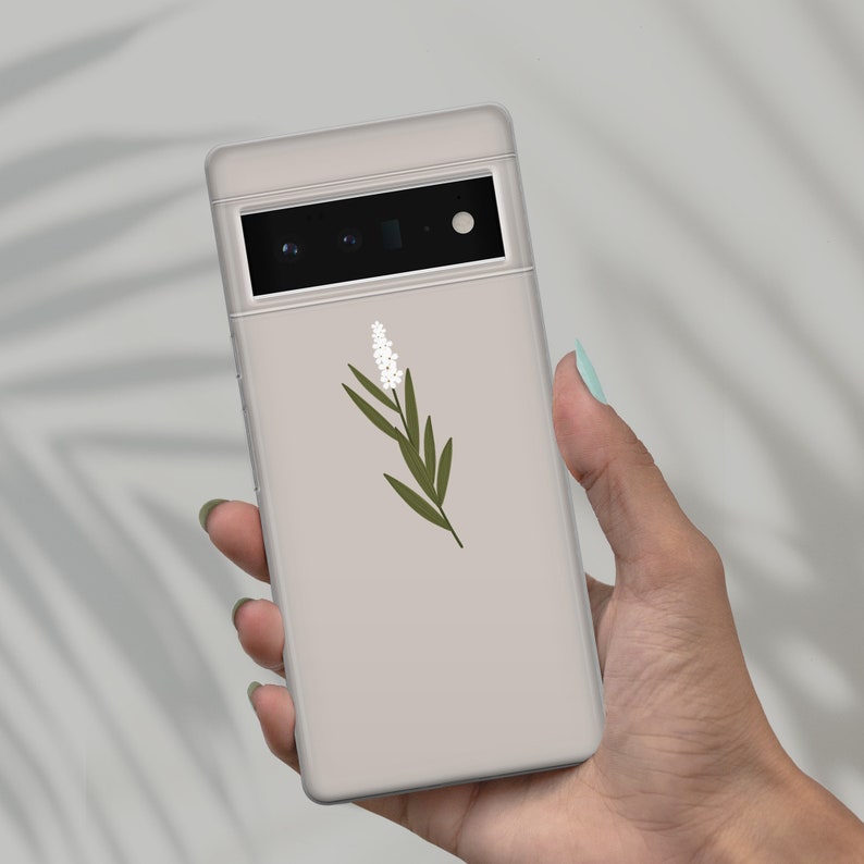May include: A light gray phone case with a white flower and green leaves design.