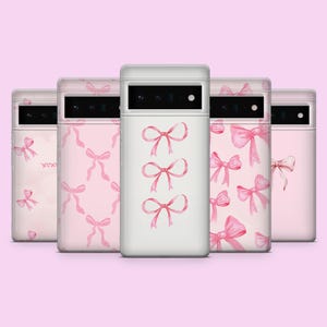 May include: Five phone cases with pink watercolor bow designs. The cases are white, pink, and light pink. The bows are different sizes and shapes.