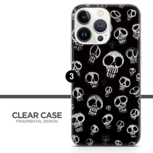 Puede incluir: Una funda transparente para tel&eacute;fono con fondo negro y un patr&oacute;n de calaveras blancas. La funda est&aacute; dise&ntilde;ada para un iPhone con un sistema de lente de c&aacute;mara triple.