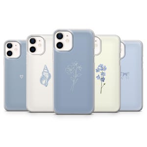 Op de afbeelding: Een verzameling van vijf telefoonhoesjes met verschillende ontwerpen. De hoesjes zijn in blauwe en witte tinten, met een hart, zeeschelp, bloemen en een strik. De hoesjes zijn voor een smartphone.