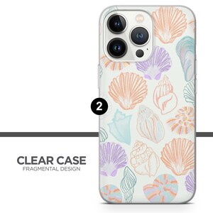 K&ouml;nnte beinhalten: Transparente Handyh&uuml;lle mit einem Design aus pastellfarbenen Muscheln auf wei&szlig;em Hintergrund. Die H&uuml;lle hat eine erh&ouml;hte Kameraabdeckung mit drei Objektiven.