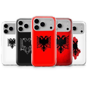 以下が含まれることがあります： アルバニアの国旗をあしらった携帯電話ケースのコレクション。ケースには、黒い双頭のワシのエンブレムが、赤、白、黒などの背景に表示されています。ケースは透明な保護素材で作られています。