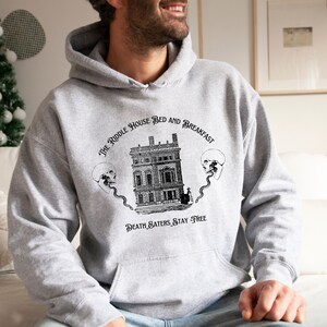May include: A gray hooded sweatshirt with a black and white graphic print of a house with the text "The Riddle House Bed and Breakfast" and "Death Eaters Stay Free".