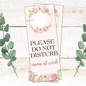 May include: Pink floral door hanger with a gold wreath and the text "PLEASE DO NOT DISTURB mama at work".
