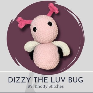 Könnte beinhalten: Ein rosa gehäkelter Käfer mit schwarzen Augen, weißen und schwarzen Flügeln und rosa Antennen. Der Käfer heißt "Dizzy the Luv Bug" und ist von "Knotty Stitches".