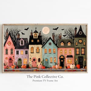 以下が含まれることがあります： The Pink Collective Co. Premium TV Frame Artと題された横長の額入りアートプリント。満月、飛ぶコウモリ、枯れ木、歩道に並ぶオレンジ色のカボチャが描かれた夜の風景の中に、カラフルな家々が並んでいる様子が表現されています。