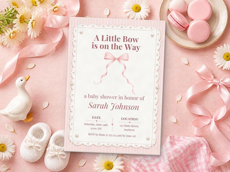 Puede incluir: Una tarjeta de invitaci&oacute;n rectangular para baby shower con borde de rayas rosas y centro blanco con una ilustraci&oacute;n de lazo rosa. El texto dice A Little Bow is on the Way, un baby shower en honor a Sarah Johnson, con fecha, lugar y detalles de RSVP.