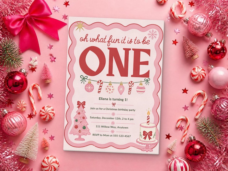 May include: A rectangular birthday invitation card with a scalloped pink border, featuring the text 'oh what fun it is to be ONE' in red, a string of ornaments, a pink Christmas tree, a cake, and event details for Eliana's first birthday.