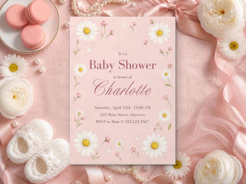 Puede incluir: Una tarjeta de invitaci&oacute;n rectangular para baby shower con fondo rosa claro, decorada con ilustraciones de margaritas blancas. El texto dice: It's a Baby Shower in honor of Charlotte, Saturday, April 12th | 11:00 AM, 123 Main Street, Anytown, RSVP to Mom @ 555.123.4567.