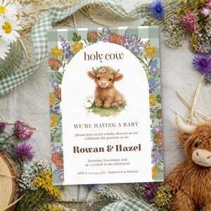 Könnte beinhalten: Eine rechteckige Einladungskarte für eine Babyparty mit grün-weißem Karomuster, einem zentralen Bogen und einer Aquarellillustration eines Highland-Kalbs mit Blumenkranz. Text: holy cow, WE'RE HAVING A BABY, Rowan & Hazel.