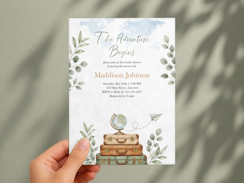 May include: A rectangular baby shower invitation card featuring a watercolor world map background, green leaf illustrations, and a stack of three vintage suitcases topped with a globe. Text reads: The Adventure Begins, Maddison Johnson.