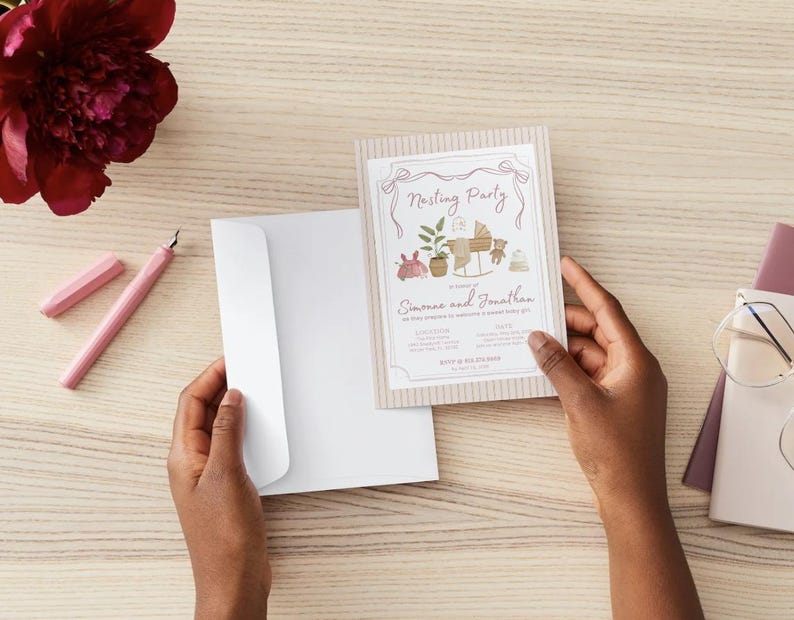 May include: A rectangular invitation card with a beige striped border and a white center featuring the text Nesting Party, Simone and Jonathan, and illustrations of a baby cradle, a potted plant, a teddy bear, and a baby hat.