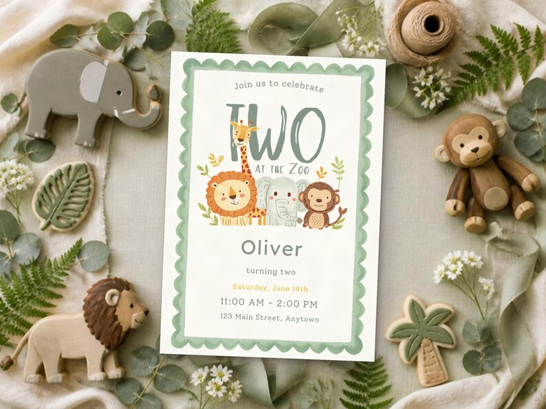 May include: A rectangular invitation card with a scalloped sage green border featuring illustrations of a giraffe, lion, elephant, and monkey. The text reads: Join us to celebrate TWO AT THE ZOO, Oliver, turning two, Saturday, June 14th, 11:00 AM - 2:00 PM, 123 Main Street, Anytown.