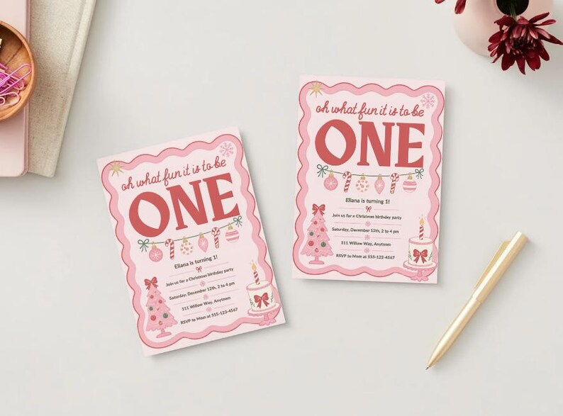 May include: Two rectangular birthday invitations with a scalloped pink border. The text reads "oh what fun it is to be ONE" in red. Graphics include a string of ornaments, a pink Christmas tree, and a cake with a single candle.