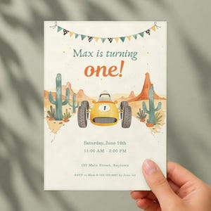 May include: A birthday invitation card featuring a yellow race car with the number one, desert cacti, and mountains. The text reads Max is turning one!, Saturday, June 14th, 11:00 AM - 2:00 PM, 123 Main Street, Anytown, and RSVP to Mom at 555.123.4567 by June 1st.