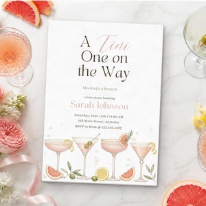 Puede incluir: Una tarjeta de invitación rectangular para baby shower con el texto A Tini One on the Way, Mocktails & Brunch, en honor a Sarah Johnson, con fecha, hora y lugar, decorada con ilustraciones en acuarela de cuatro copas de cóctel y cítricos.