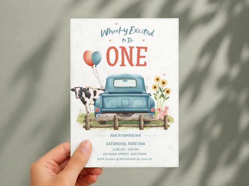 May include: A birthday invitation card featuring a blue pickup truck, a cow, a pig, and sunflowers behind a wooden fence. Text reads: Wheel-y Excited to Be ONE, Max is turning one, Saturday, June 14th, 11:00 AM - 2:00 PM, 123 Main Street, Anytown, RSVP to Mom @ 555.123.4567 by June 1st.