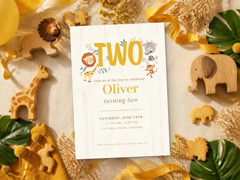May include: A rectangular birthday invitation card with the text TWO, featuring illustrations of a lion, giraffe, elephant, and monkey. The card includes the name Oliver, the date Saturday, June 14th, and event details, surrounded by wooden animal figures.