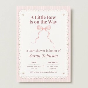 Puede incluir: Una tarjeta de invitaci&oacute;n rectangular para baby shower con fondo de rayas rosa claro y un panel central blanco con borde de encaje y detalles de perlas. El texto dice A Little Bow is on the Way, Sarah Johnson, y los detalles.