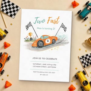 May include: A rectangular birthday invitation card featuring an orange race car with the number 2, checkered flags, and a gold trophy. The text reads: Two Fast, Max is turning 2!, JOIN US TO CELEBRATE, SATURDAY, JUNE 14TH @ 1PM, 123 MAIN STREET, ANYTOWN, RSVP TO MOM @ 555-123-4567 BY JUNE 1ST.