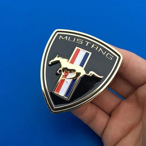 Emblema delantero Mustang Pony cromado, con licencia Ford, nuevo, 2015-22, tricolor, 2 piezas. Shield Black&Gold