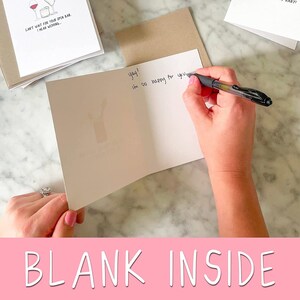 May include: A blank greeting card with the text "yay! I'm so happy for you" written on the inside. The card is folded in half and the front is blank.