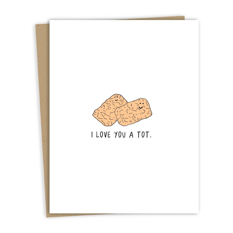 May include: A white card with a drawing of two tater tots with smiley faces. The text "I love you a tot." is printed below the tots.