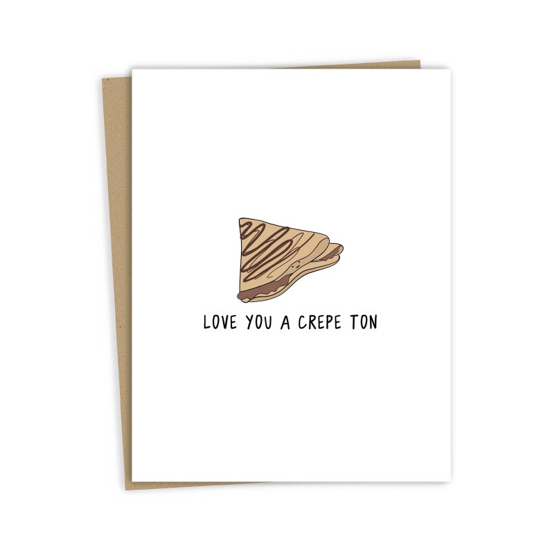 May include: A white card with a brown crepe illustration and the text "Love you a crepe ton".