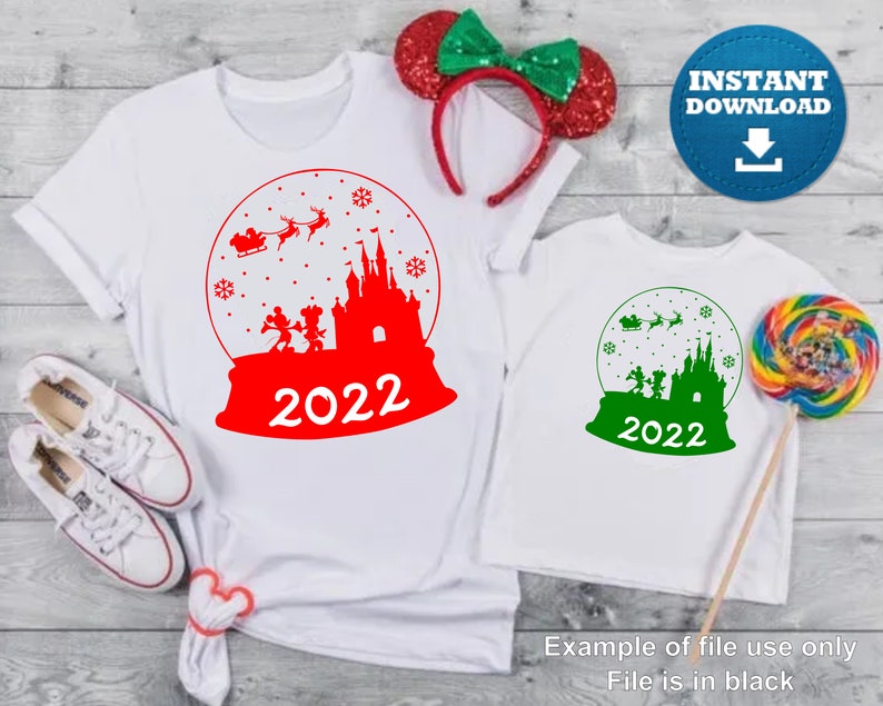 May include: Red and green Christmas-themed iron-on design featuring a snow globe with Mickey Mouse and friends in front of Cinderella's Castle. The design includes the text "2022".