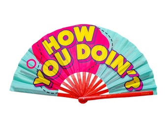 May include: A blue and pink hand fan with a red handle. The fan has the text "HOW YOU DOIN?" printed on it in yellow and pink letters.