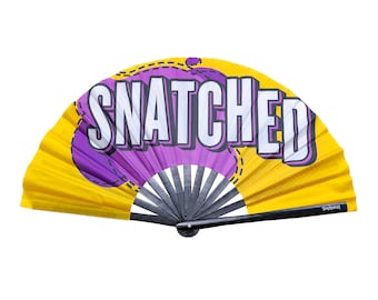 May include: A yellow and purple hand fan with the word "SNATCHED" printed on it in white letters.