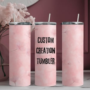 May include: Three pink marble-patterned stainless steel tumblers with black lids and straws. The middle tumbler has the text "CUSTOM CREATION TUMBLER" printed on it.