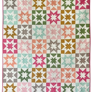 May include: A colorful quilt featuring a repeating star pattern in various colors including pink, green, gold, and gray. The quilt has a white background and a pink border. The star blocks are arranged in a grid.