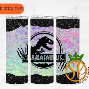 Puede incluir: Tres vasos de acero inoxidable con acabado de purpurina negra y un diseño holográfico iridiscente. Los vasos presentan una silueta negra de un dinosaurio con el texto "Amasaurus" en un círculo a su alrededor.