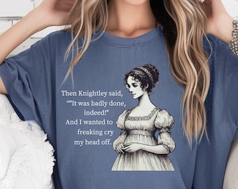 May include: A blue t-shirt with a black and white illustration of a woman in a dress. The text on the shirt reads "Then Knightley said, "It was badly done, indeed!" And I wanted to freaking cry my head off."