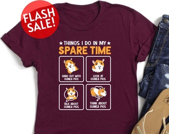 May include: A maroon t-shirt with a white graphic that says "Things I do in my spare time" and has four illustrations of guinea pigs. The illustrations show a guinea pig hanging out, looking at something, talking, and thinking.