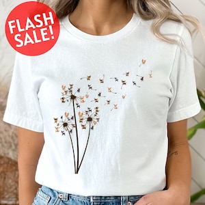 a woman wearing a white t - shirt with a dandelion design
