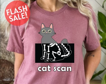 May include: A maroon t-shirt with a black and white image of a cat skeleton with the text "cat scan" underneath.