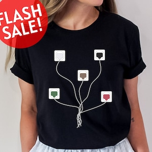 May include: A black t-shirt with a graphic of a tree made of electrical cords and outlets. The outlets are in different colors: white, black, brown, green, and red.