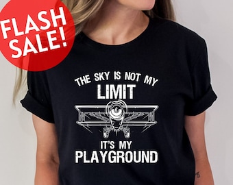 Może przedstawiać: Czarny T-shirt z białym nadrukiem vintage'owego samolotu i tekstem "Niebo nie jest moim limitem, to mój plac zabaw".