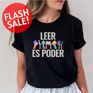May include: Black t-shirt with the text "Leer es Poder" in white lettering. The text is surrounded by colorful illustrations of hands holding books.