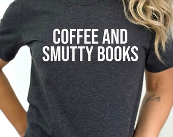 May include: A dark heather grey t-shirt with the text "COFFEE AND SMUTTY BOOKS" printed in white.